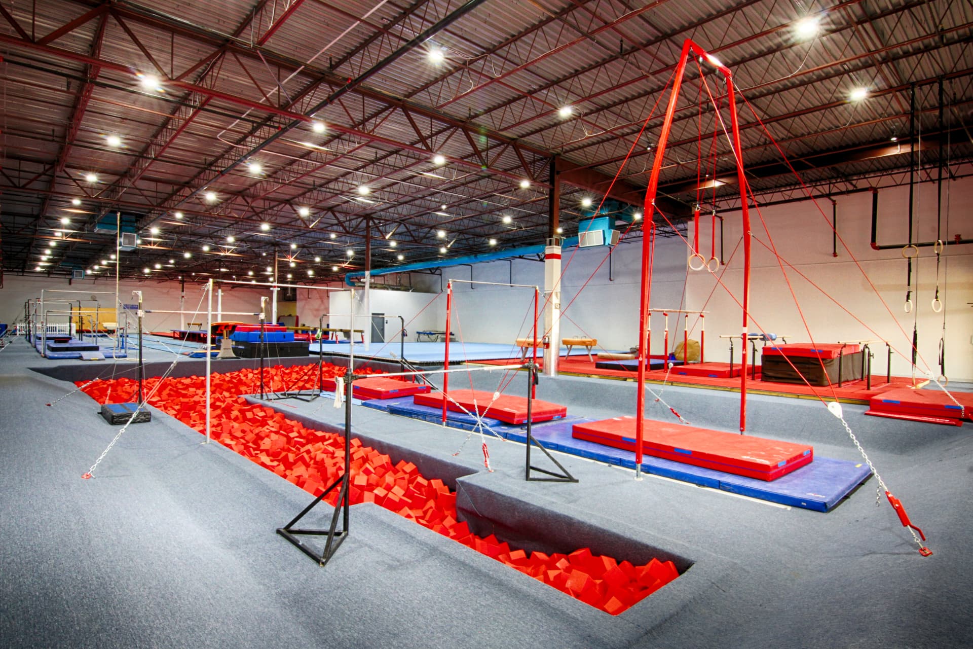The Gymnastics USA training floor with bars, foam pit and mats